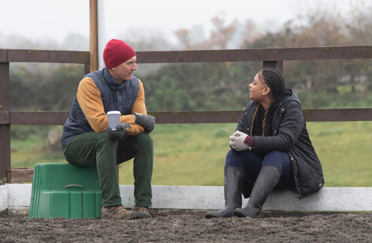 Man And Woman Talking In Equestrian Arena